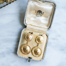 Load image into Gallery viewer, Gold earrings in an open jewelry box on a marble surface
