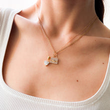 Load image into Gallery viewer, Gold necklace with heart and bag pendant on a person wearing a white top.

