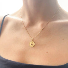 Load image into Gallery viewer, Gold necklace with a pendant on a person wearing a black top.
